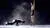 Zwarte ruimte gevuld met rook, een danseres rechts staand op spitzen en een breakdancer daarnaast op de vloer