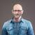Lachende kale man met bril en jeans overhemd