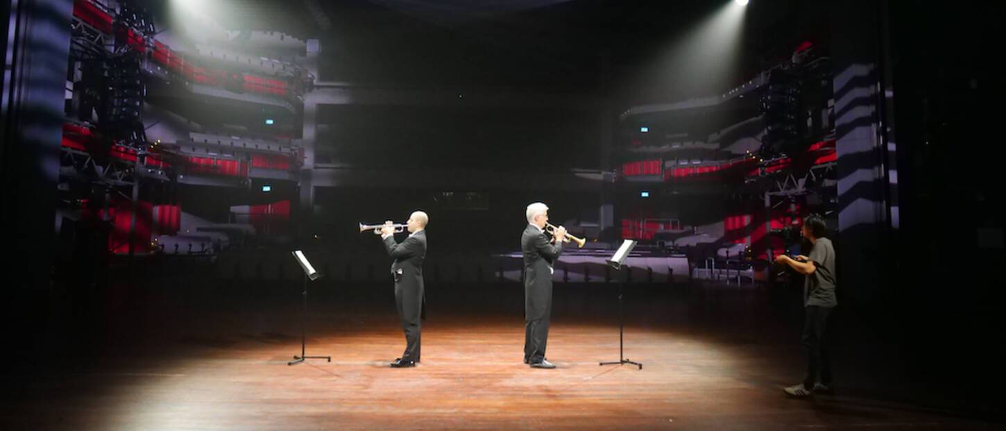 Een leeg theater met op het podium 2 trompettisten