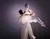 Twee dansers in duet tegen een paarse achtergrond in witte kleding